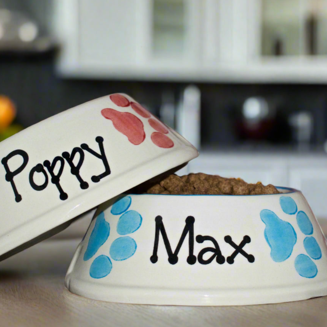Two pet bowls with names 'Poppy' and 'Max' on a kitchen counter.
