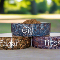 Three pet bowls with names written on them outdoors